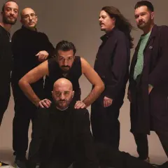 I Negramaro, in posa per "Quel posto che non c'è", sei uomini con sguardi intensi e abiti scuri.