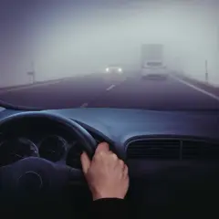 Conduciendo en carretera con poca visibilidad por niebla. Hay poca visibilidad por niebla, ¿qué debe hacer? Reducir velocidad y usar luces antiniebla.