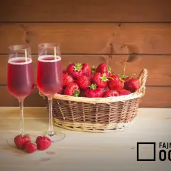 Dwa kieliszki z różowym napojem i koszyk pełen świeżych truskawek. Idealne na letnie popołudnie, może to wino z truskawek?