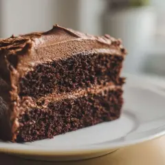 Une part généreuse de cake au chocolat, avec un glaçage onctueux et une texture moelleuse. Un délice pour les amateurs de chocolat.