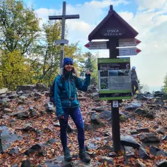 Kobieta na szczycie Łysicy, najwyższego szczytu Gór Świętokrzyskich. Jesienne liście i kamienie wokół.