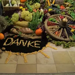 Ein liebevoll gestalteter Erntedankaltar mit Gemüse, Früchten, Brot und dem Wort "Danke" aus Mais.