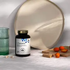 Flasche L-Tryptophan, die Vorstufe für Serotonin, neben Gläsern und Kumquats.