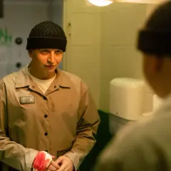 Chłopak w czapce i beżowej kurtce, z bandażem na ręce, patrzy w lustro. Scena z freestyle film.