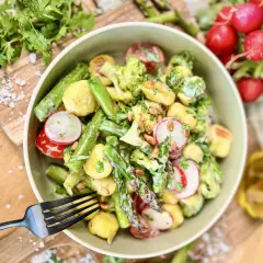 Leckerer Gnocchi Salat mit Spargel, Brokkoli, Radieschen und Pinienkernen, garniert mit frischer Petersilie.