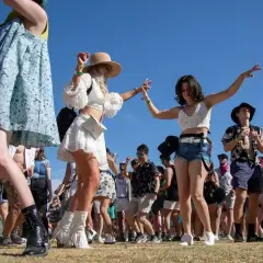 Giovani ballano felici in un boutique festival sotto il sole.