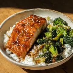 En skål med ris, saftig teriyaki lax toppad med sesamfrön och ångad broccoli. En perfekt middag.