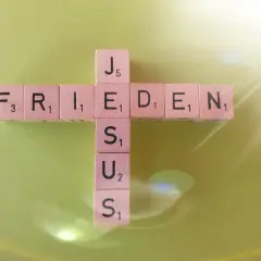 Frieden lasse ich euch, meinen Frieden gebe ich euch. Johannes 14,27. Holzbuchstaben bilden ein Kreuz mit den Wörtern FRIEDEN und JESUS.
