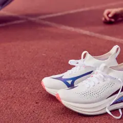 Białe buty do biegania Mizuno Neo Vista 2 z niebieskimi akcentami na bieżni.