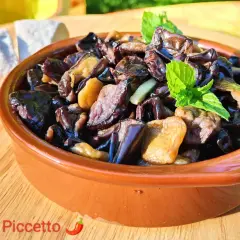 Melanzane alla scapece in terracotta, guarnite con menta fresca, accanto a pane casereccio. Un piatto estivo che profuma di tradizione.