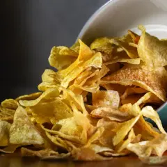Chrupiące chipsy z airfryera wysypują się z turkusowej miseczki. Idealna przekąska!