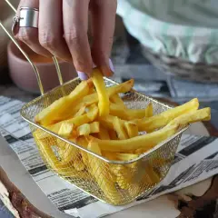 En hand plockar upp en gyllene pommes frites ur ett korgfat. Perfekt för en snabb aptitretare.