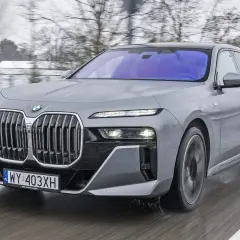 Szare BMW Serii 7 w ruchu, zimowy krajobraz. Zastanawiasz się, ile kosztuje nowe BMW 7?