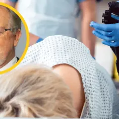 Lekarz w okularach i brodzie wyjaśnia, czy kolonoskopia boli. W tle pacjentka i sprzęt medyczny.