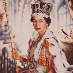 Elizabeth II av Storbritannien, krönt och med spira, sitter på tronen i sin kungliga dräkt.