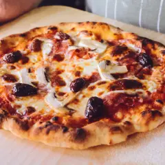 Idealna pizza na kamieniu: chrupiące ciasto, ciągnący ser, oliwki i pieczarki. Sekret jak piec pizze na kamieniu tkwi w wysokiej temperaturze.