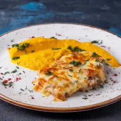 Pyszne katsu z serem zapieczonym na wierzchu, podane z purée z dyni i posypane ziołami.