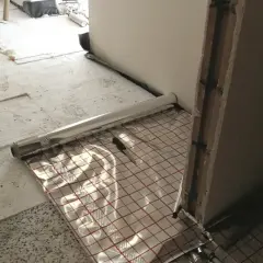 Przygotowania do wylewania posadzki z ogrzewaniem podłogowym. Folia izolacyjna z siatką.