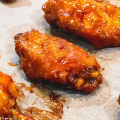 Saftige Hähnchenflügel in einer glänzenden, würzigen Marinade, bereit zum Genuss.