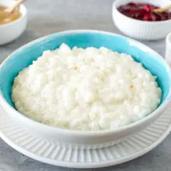 Cremiger Milchreis im blauen Schälchen, bereit für Apfelmus, Kirschen oder Zimt. Ein einfaches Milchreis Rezept für jeden Tag.