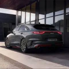 Nowoczesna Kia Proceed, której historia sięga Korei Południowej, prezentuje się dynamicznie na tle architektonicznego budynku.
