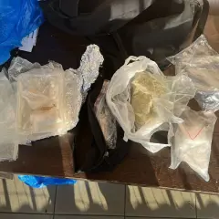 Różne substancje w foliowych i plastikowych opakowaniach na drewnianym stole.