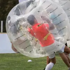 Gracze w wielkich, przezroczystych kulach zderzają się podczas gry w bubble football.