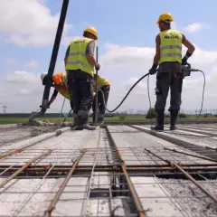 Budowa stropu: pracownicy wylewają beton, używając pompy. Jaki beton na strop? Ten, który zapewni trwałość konstrukcji.