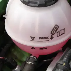 Zbiorniczek z różowym płynem chłodniczym w silniku. Poziom płynu G13 jest między min a max.