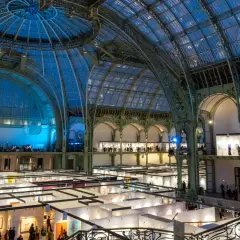 Vue intérieure du Grand Palais à Paris, une exposition d'art se déroule sous sa verrière spectaculaire.