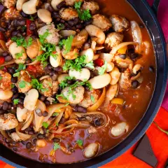 En mustig korvgryta med bönor och lök, perfekt för ett mysigt middagsrecept. Serveras med rödvin och chili.
