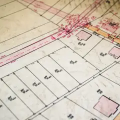 Stary plan geodezyjny z zaznaczonymi działkami i budynkami. Pomocny przy poszukiwaniach, jak znaleźć właściciela działki po numerze.