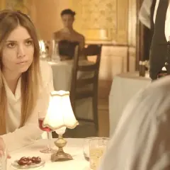 Lykke Li w białej bluzce, zamyślona przy stoliku. Czyżby "sadness is a blessing"?