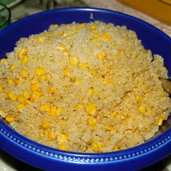 En blå skål fylld med fluffig quinoa och söta majskorn. Perfekt för att koka quinoa till en hälsosam måltid.