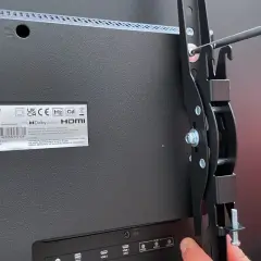 Montaż telewizora na ścianie bez uchwytu? To możliwe! Wkręcanie elementów mocujących do tyłu telewizora Sharp.