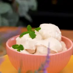 En skål med krämig, nyttig glass toppad med myntablad. En härlig sommardessert som passar alla.
