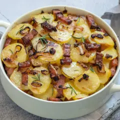 Zapiekanka ziemniaczana z boczkiem i rozmarynem w naczyniu żaroodpornym.