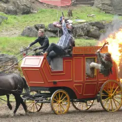 Ein Wagen brennt bei einer Karl May Inszenierung in Elspe. Zwei Männer kämpfen, einer fällt aus dem brennenden Wagen.