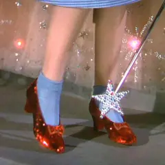 Sennik czerwone buty: Błyszczące, rubinowe pantofelki z kokardkami i magiczna różdżka z gwiazdą.
