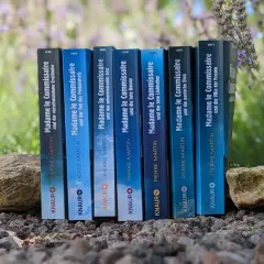 Reihenfolge der "Madame le Commissaire"-Bücher von Pierre Martin, aufgestellt zwischen Steinen und Lavendel.