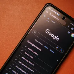 Telefon z ciemnym motywem Google, wyświetlający wyszukiwane hasła, w tym "next pandemic disease x". Ustawienia safesearch są aktywne.