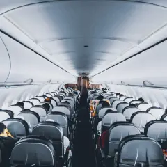 Wnętrze samolotu Wizz Air, rzędy siedzeń wypełnione pasażerami. Wizz Priority zapewnia komfortową podróż.