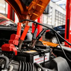 Kable rozruchowe podłączone do akumulatora samochodowego. Zastanawiasz się, ile ładować akumulator 70ah? Czas ładowania zależy od prostownika i stopnia rozładowania.