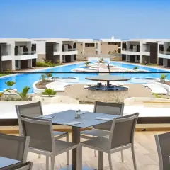 Luksusowy resort Royal Horizon Ponta Sino z basenem i barem. Stoły na tarasie czekają na gości.