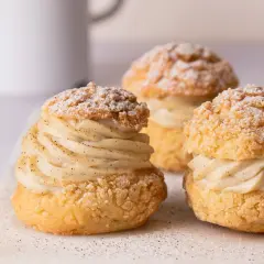 Trois délicieux choux garnis de crème pâtissière à la vanille, saupoudrés de sucre glace. Un vrai plaisir gourmand à base de pâte à choux.
