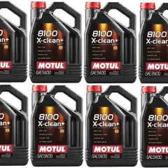 Cztery czarne kanistry oleju silnikowego Motul 8100 X-clean+ 5W30 z czerwonymi nakrętkami.