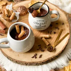 Cioccolata calda cremosa in tazza, con biscotti arrotolati e tavoletta di cioccolato. Un abbraccio goloso per le giornate autunnali.