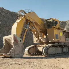 Ogromna, żółta koparka Komatsu, największa tego typu maszyna, pracuje w kamieniołomie.