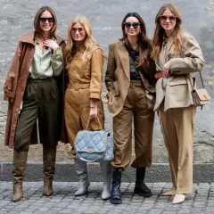 Vier Frauen in erdigen Tönen zeigen, was man bei 10 Grad anzieht: Leder-Trenchcoat, Anzüge und Stiefel.
