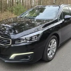 Czarny Peugeot 508 kombi z silnikiem 2.0 HDI 150KM na leśnej drodze.
